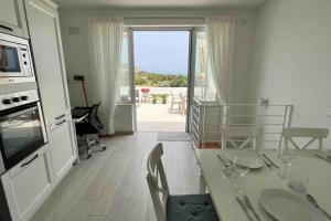 ein Esszimmer mit einem Tisch und eine Küche mit Aussicht in der Unterkunft Brand new 3-level sea view apartment near beach in Il-Pergla