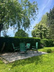 trzy zielone krzesła i stół w trawie w obiekcie Apartment in Ljubljana w Lublanie