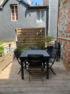 a black table and chairs on a wooden deck at Honfleur effet mer 2 in Honfleur