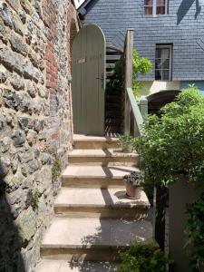 a stone building with a door and stairs in front of it at Honfleur effet mer 2 in Honfleur