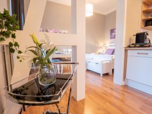 een vaas met bloemen op een glazen tafel in een kamer bij EUPHORAS - Central & Stylish Apartment - Parking in Bad Harzburg +8 foto's