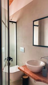 a bathroom with a sink and a tub and a mirror at ELÉA Guesthouse himare in Himare
