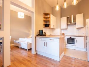 een keuken met witte kasten en een woonkamer bij EUPHORAS - Central & Stylish Apartment - Parking in Bad Harzburg