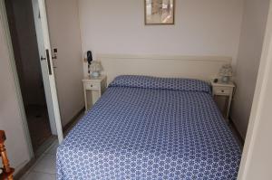 a bedroom with a bed with a blue and white comforter at Hotel Ondina in Viareggio