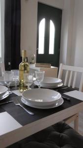 uma mesa com um prato branco e uma garrafa de vinho em SaafePlace-4pers-Wifi-KeyBox-24sur7 em Étampes