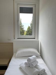 a bedroom with two towels on a bed with a window at Kino Apartment in Tirana