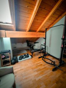 une chambre avec salle de sport dans un loft doté de plafonds en bois dans l'établissement Mountain View Hideaway, à Ballabio