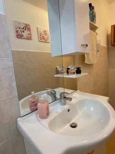 een badkamer met een witte wastafel en een spiegel bij Lavender Cottage in Balatongyörök
