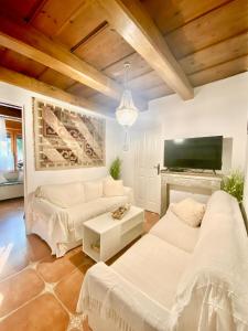 a living room with a couch and a tv at Lavender Cottage in Balatongyörök