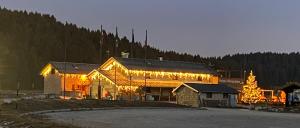 a large wooden building with lights on it at Malga Millegrobbe Nordic Resort in Lavarone