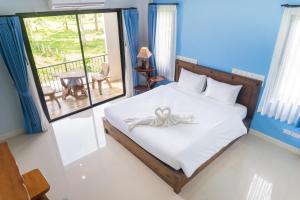 a bedroom with a bed with a bow on it at Krabi Lighthouse @ Aonang in Ao Nang Beach