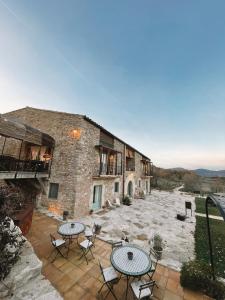 a building with tables and chairs on a patio at ECOTurisme Can Buch HOTEL in Sant Aniol de Finestras