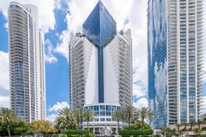 a group of tall buildings with palm trees in front of them at TRUMP INTL 2 BEDROOM APARTMENT 1600 Sqf Ocean and Bay View in Miami Beach