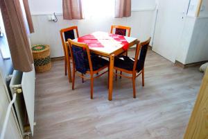 une table à manger avec quatre chaises et une table à damier rouge et blanc dans l'établissement APARTMÁNY SLAVIE/SEGA TROJANOVICE, à Trojanovice