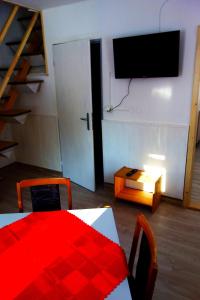 sala de estar con mesa y TV en la pared en APARTMÁNY SLAVIE/SEGA TROJANOVICE, en Trojanovice