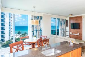 a kitchen with a living room with a view of the ocean at TRUMP INTL 2 BEDROOM APARTMENT 1600 Sqf Ocean and Bay View in Miami Beach