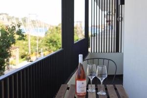 a bottle of wine and two wine glasses on a table at Uphill Unique Boutique Suites in Skiathos