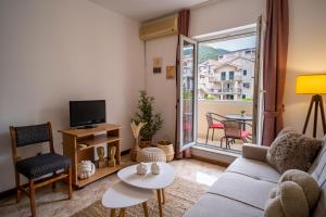 a living room with a couch and a tv at Villa Maxima Budva in Budva