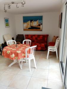 een woonkamer met een tafel en stoelen en een bank bij WIM GOLF in Wimereux