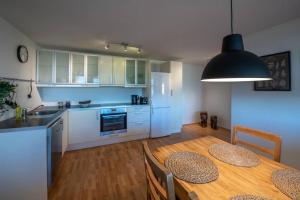 a kitchen and dining room with a wooden table with chairs at Lovely one bedroom apartment in Hafnarfjordur in Hafnarfjördur