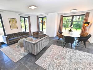 un salon avec des canapés, une table et des chaises dans l'établissement Villa LEVANTE in Binz - Penthouse mit Kamin, Sauna, Seeblick, à Binz