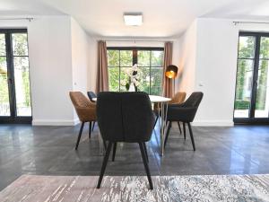 une salle à manger avec une table et des chaises dans l'établissement Villa LEVANTE in Binz - Penthouse mit Kamin, Sauna, Seeblick, à Binz