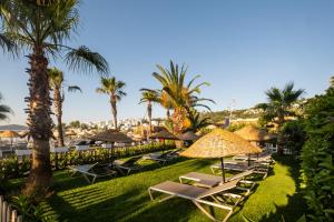 a row of lounge chairs and umbrellas at a resort at Costa Bitezhan Hotel - All Inclusive in Bitez
