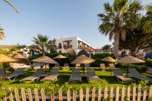 een groep ligstoelen en parasols voor een resort bij Costa Bitezhan Hotel - All Inclusive in Bitez