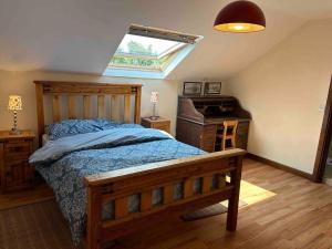 ein Schlafzimmer mit einem Holzbett und einem Fenster in der Unterkunft Apartment - Clonlyne House in Oldcastle