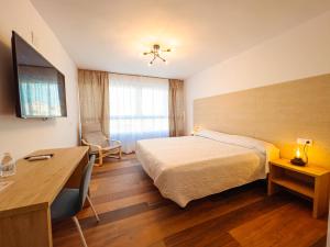 a hotel room with a bed and a desk at Hostal Sorbas in Sorbas