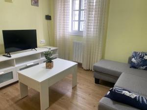 un soggiorno con divano, TV e tavolo di Dúplex en Vigo, zona de Bouzas, Cerca de las playas a Vigo