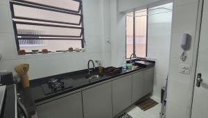 a kitchen with a sink and a window at Lindo Apartamento compacto na quadra da praia in Santos