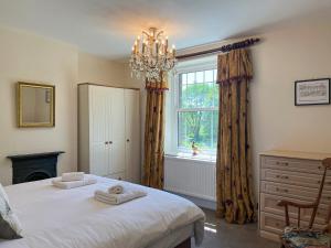 a bedroom with a bed and a window at Puddle Duck Cottage in Bakewell