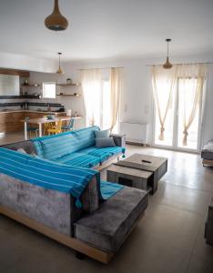 a large living room with a blue couch and tables at Holiday Lefkas Sunrise Luxury Appartments in Nikiana