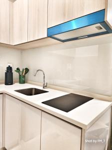 a kitchen with white cabinets and a sink at Seaview Luxury Suites at The Shore Kota Kinabalu in Kota Kinabalu