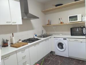 a kitchen with a washing machine and a sink at Villa Antonia in Chipiona +23 photos