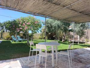a white table and chairs under a pergola at Villa Antonia in Chipiona