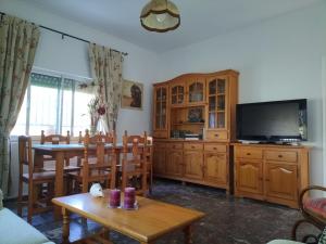 a living room with a dining table and a television at Villa Antonia in Chipiona