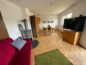 a living room with a red couch and a flat screen tv at Flussnest Fulda in Fulda