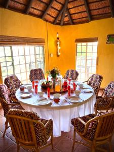 a dining room table with a white tablecloth and chairs at Kruger River View in Marloth Park