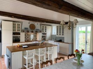 a kitchen with white cabinets and a wooden counter top at Entire Farm House stay, La Gérouardière in Barenton