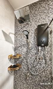 um chuveiro na casa de banho com uma cabeça de chuveiro em Seaview Luxury Suites at The Shore Kota Kinabalu em Kota Kinabalu