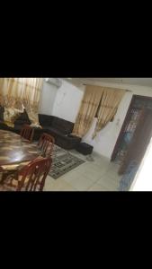 a room with a table and chairs and curtains at Amar ak house in Mombasa