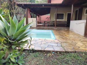a swimming pool in the backyard of a house at Sítio Recanto do Paturi in Piranguinho