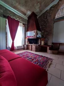 1 dormitorio con cama roja y chimenea en Agriturismo Il Borgo della Canapa, en San Benedetto