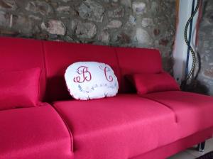 ein rotes Sofa mit einem weißen Kissen drauf in der Unterkunft Agriturismo Il Borgo della Canapa in San Benedetto