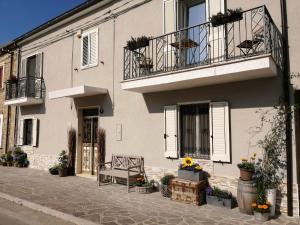 Biały dom z ławką i balkonem w obiekcie casa rosa abruzzo w mieście Musellaro