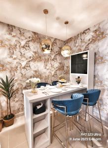 a dining room with a white table and blue chairs at Seaview Luxury Suites at The Shore Kota Kinabalu in Kota Kinabalu