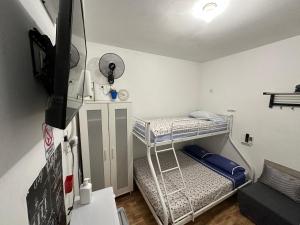 a small room with a bunk bed and a tv at CASA SUR APARCAMIENTO GRATIS in Córdoba
