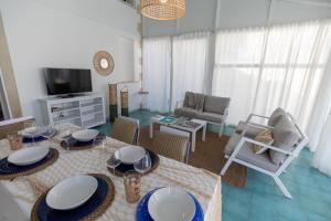 - un salon avec une table, des chaises et une télévision dans l'établissement SICILY SUN CON ACCESSO SPIAGGIA, à Santa Maria Del Focallo
